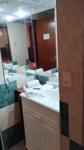 a bathroom with a sink and a large mirror at Hotel Valle Del Sol in Merlo