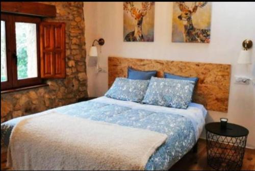 Sagasta Rural - Oviedo في أوفِييذو: غرفة نوم بسرير كبير مع وسائد زرقاء