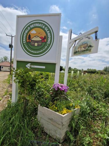 a sign for a farm with flowers in a field at Cranfield Retreat & Glamping in Long Melford