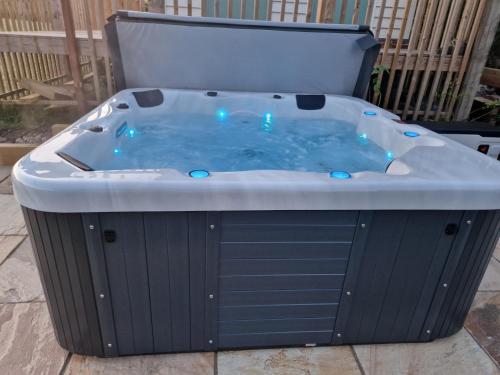 a jacuzzi tub with blue lights in a yard at Cranfield Retreat & Glamping in Long Melford