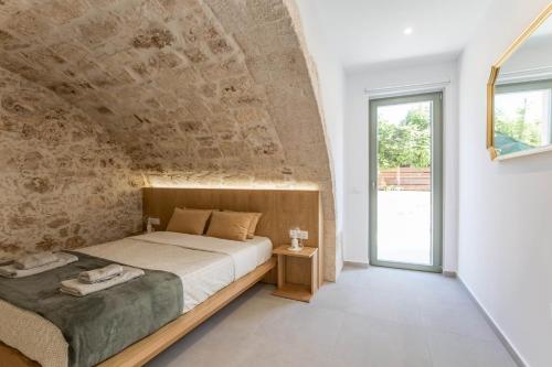 um quarto com uma cama grande e uma parede de pedra em Lindas Convent Garden Home 1 em Chania Town