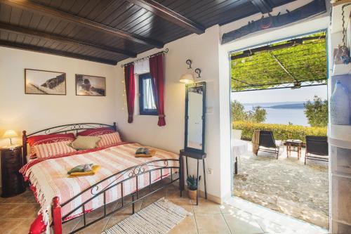 a bedroom with a bed and a view of the ocean at Holiday home Oaza in Baška Voda