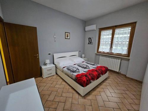 ein Schlafzimmer mit einem Bett mit roten Rosen darauf in der Unterkunft Casa con incantevole panorama in Bevagna