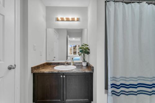 a bathroom with a sink and a mirror at Elevate Your Family Getaway in Oshawa with the brand new Luxury Villa in Oshawa