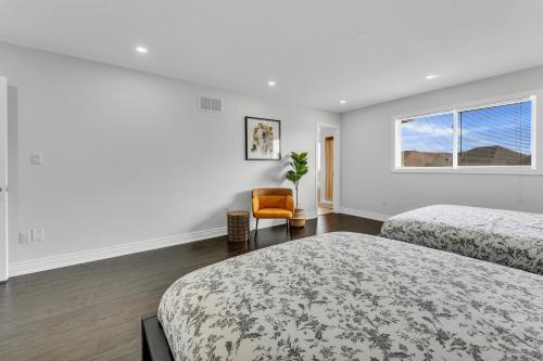 a white room with two beds and a window at Oshawa Family Haven - Luxury 7BR Villa with Cozy Fireplaces & Hot Tub in Oshawa