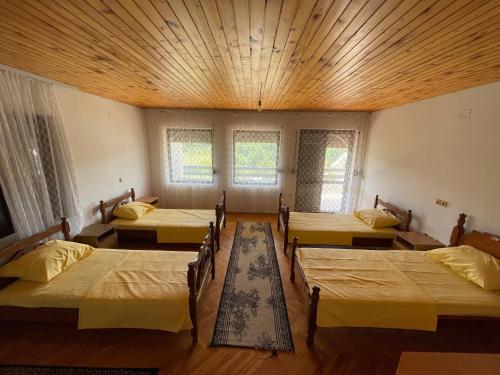 a room with four beds and a wooden ceiling at Summer Sky in Ulcinj