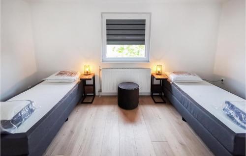 duas camas num quarto com uma janela e dois candeeiros em Kavel 11 em Den Oever