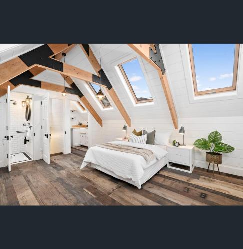 een slaapkamer met een groot wit bed op een zolder bij A Majestic Victorian Private Rear Access Quarters in Melbourne