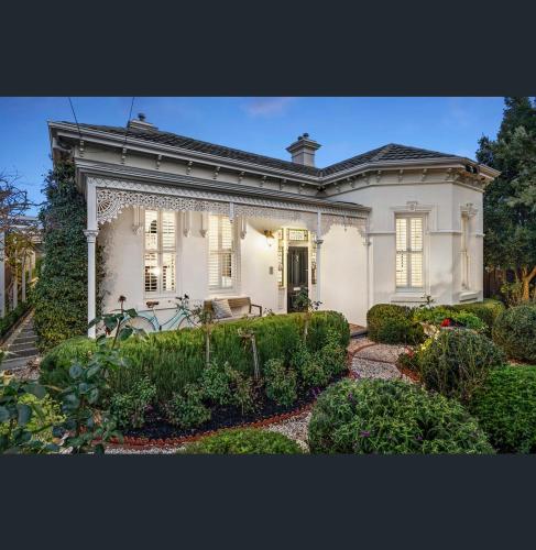 a white house with a garden in front of it at A Majestic Victorian Private Rear Access Quarters in Melbourne