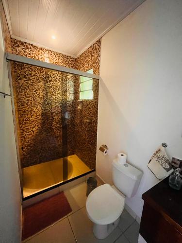 a bathroom with a toilet and a glass shower at Fauna in Praia do Bananal