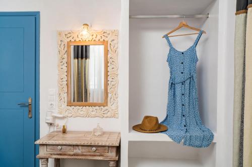 un vestito blu appeso a un muro accanto a uno specchio di Cozy little house in Ios a Ios Chora