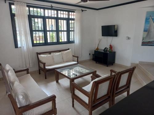 a living room with a couch and a table at Pendo Residences - Villa 3Br Beachfront in Diani Beach
