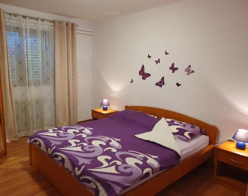 1 dormitorio con 1 cama con mariposas en la pared en Apartments Sara en Labin
