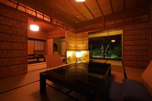 um quarto com uma mesa e duas cadeiras e um candeeiro em ふきや旅館 Fukiya Ryokan em Yugawara
