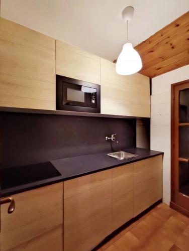 a kitchen with a sink and a microwave at Bellagio Ghisallo Penthouse in Bellagio