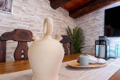 un jarrón blanco sentado sobre una mesa en Casa Rural El Burrito de Gredos en Pedro Bernardo