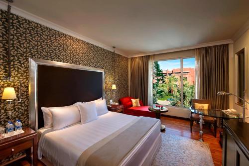 a hotel room with a bed and a large window at ITC Rajputana, a Luxury Collection Hotel, Jaipur in Jaipur