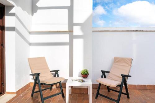 - une terrasse avec 2 chaises et une table dans l'établissement Cómodo apartamento en Almonte, à Almonte