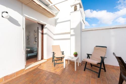 d'une terrasse avec deux chaises et une table. dans l'établissement Cómodo apartamento en Almonte, à Almonte