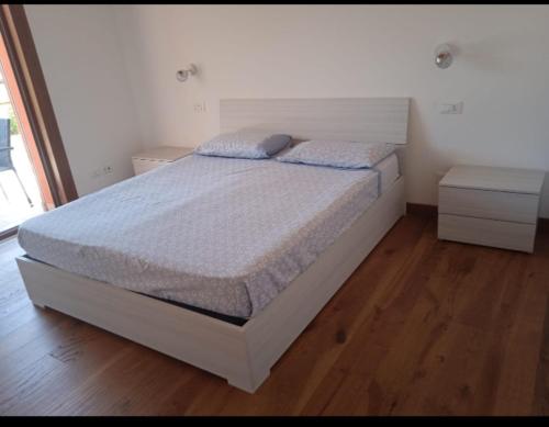 - une chambre avec un lit blanc et du parquet dans l'établissement Ca' Giorgio, à Cavallino-Treporti
