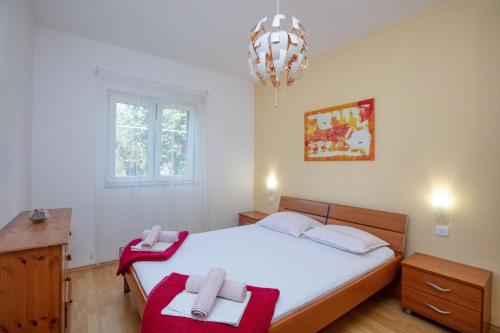 1 dormitorio con 1 cama con 2 toallas en Apartments by the sea Rogoznica - 10268, en Rogoznica
