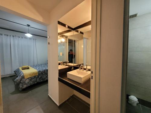 ein Badezimmer mit Waschbecken, Bett und Spiegel in der Unterkunft Departamento Mis Nonos 2 in Mendoza