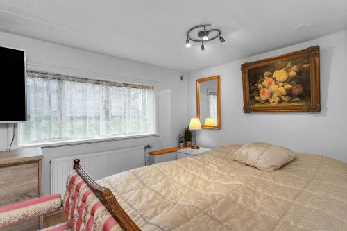 a bedroom with a bed and a painting on the wall at Lara Studio in Laugardalur valley, Reykjavík Central Park and Botanical Garden, Private entrance, FREE Private Parking on side in Reykjavík
