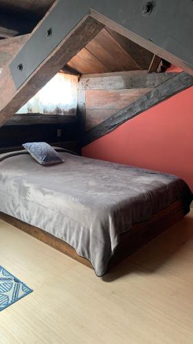 a large bed in a room with a red wall at Casa Tequio in San Cristóbal de Las Casas