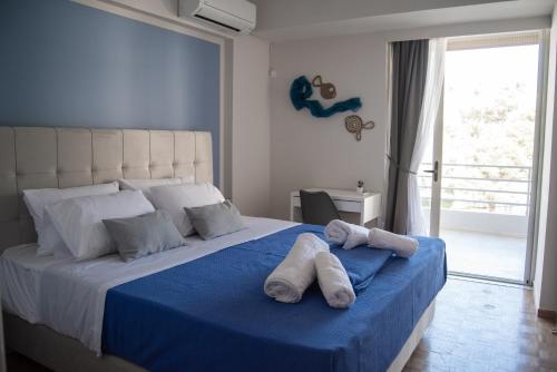 - une chambre avec un grand lit et des serviettes dans l'établissement Naiads Nest - The Blue Wave, à Varkiza