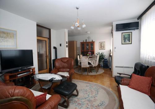 a living room with leather chairs and a flat screen tv at Snowball in Pale