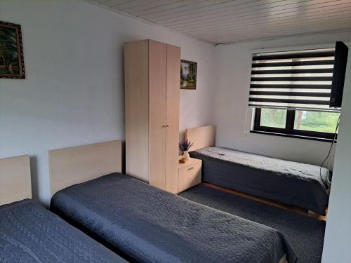 a small bedroom with two beds and a window at Apartmani Bosna Visoko in Visoko