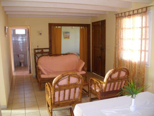 ein Wohnzimmer mit 2 Stühlen und einem Bett in der Unterkunft Villa Herifanja Antsirabe in Antsirabe