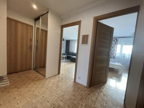a room with two sliding doors and a living room at Apartament ENJOY Zator - z widokiem na Energylandie in Zator