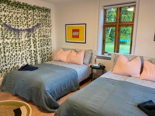1 dormitorio con 2 camas y ventana en STAY Billund, en Vandel