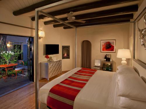 a bedroom with a large bed and a living room at Palacio de Marquesa in Taos