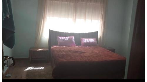 um quarto com uma cama com duas almofadas e uma janela em Apparemment près Anfa parc em Casablanca