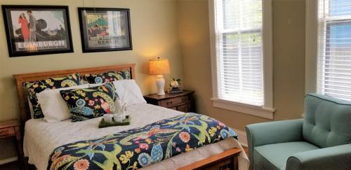 a bedroom with a bed and a blue chair at Urban Cottages in Little Rock