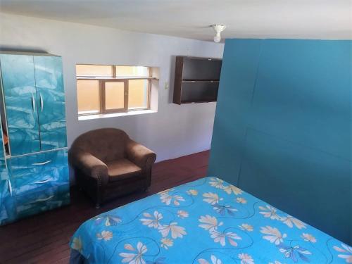 a bedroom with a bed and a chair and a window at mini-hogar en santa teresa in Santa Teresa