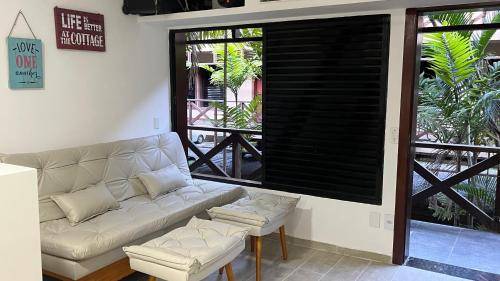 a living room with a white couch and a large window at Eco Paradise 110 - Cumbuco in Caucaia