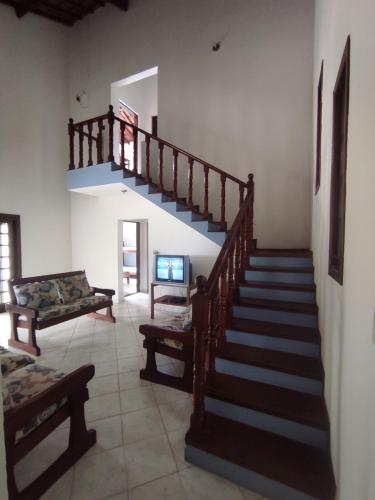 uma sala de estar com uma escada e um sofá em Chalés Carioca Prumirim Ubatuba em Ubatuba