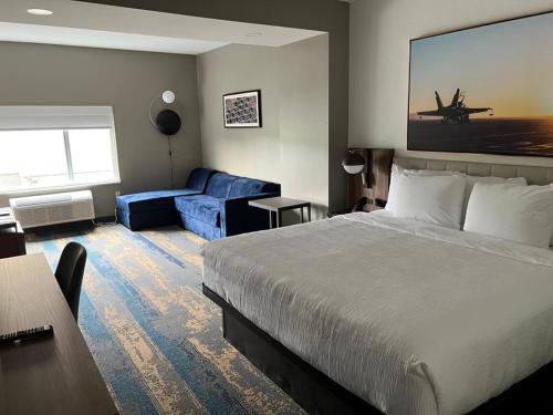 a hotel room with a bed and a couch at La Quinta Inn & Suites by Wyndham Manchester - Arnold AFB in Manchester