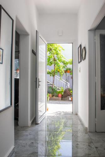 a hallway with an open door with a view of a courtyard at (Stoa escape) traditional home in Archangelos