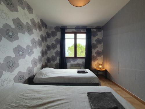 een slaapkamer met 2 bedden en een raam bij Le Rêve de Montbrun in Montbrun-des-Corbières