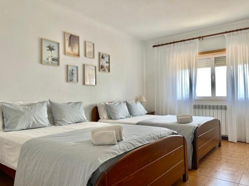 a bedroom with two beds and a window at Colina do Elétrico in Figueira da Foz