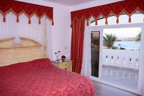 una camera con un letto rosso e una grande finestra di Elba Luxury Villa a Sharm El Sheikh