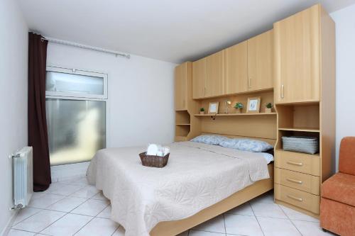 ein Schlafzimmer mit einem Bett und einem Korb darauf in der Unterkunft Apartments with a parking space Brsec, Opatija - 7755 in Brseč
