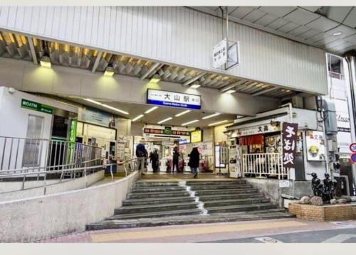 un bâtiment avec des escaliers et des personnes qui le traversent dans l'établissement 大山駅徒步4分平层90㎡超大客厅光线充沛（池袋至近）, à Tokyo