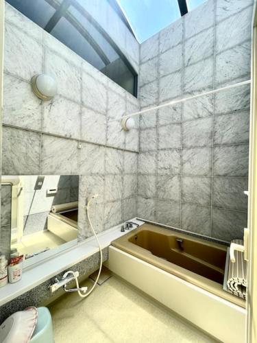 a bathroom with a bath tub and a mirror at 池袋三駅の家 大山駅から徒歩4分 in Tokyo