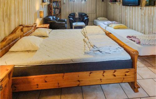 two wooden beds in a room with a chair at 4 Bedroom Pet Friendly Home In Simrishamn in Simrishamn