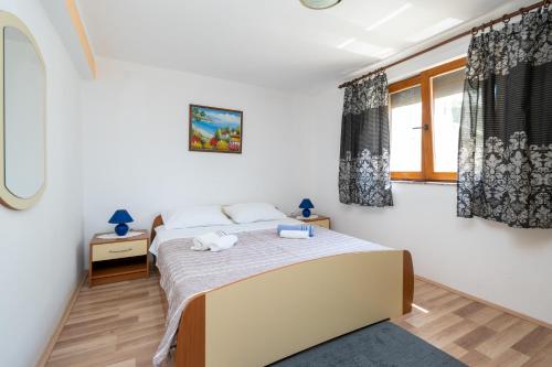 Schlafzimmer mit einem Bett und einem Fenster in der Unterkunft Apartments with a parking space Mrljane, Pasman - 20056 in Pašman